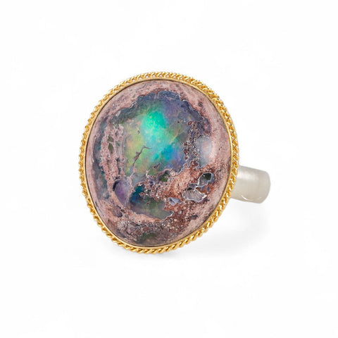 Ring with a mexican opal stone and 18k gold bezel with a sterling silver band on a white background
