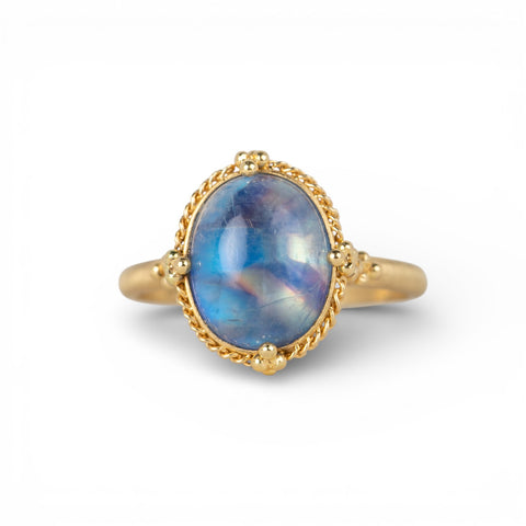 Gold ring with a moonstone on a white background