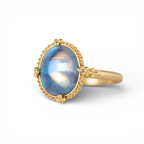 Gold ring with a moonstone on a white background
