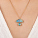 Opal and aquamarine pendant mushroom necklace with gold chain on a person