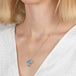 Opal and aquamarine pendant mushroom necklace with gold chain on a person