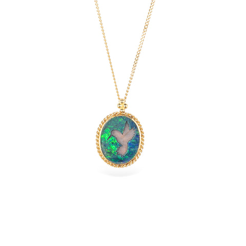 Handmade opal doublet pendant necklace featuring a carved hummingbird on a gold chain against a white background.