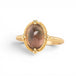 Gold ring with a sunstone on a white background