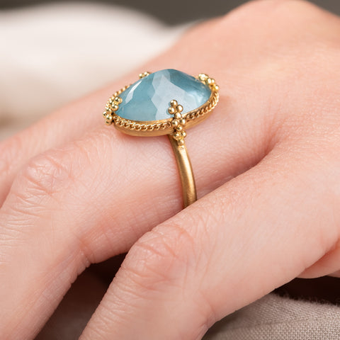 A photo that shows the fine details of the handmade gold setting of an aquamarine ring.