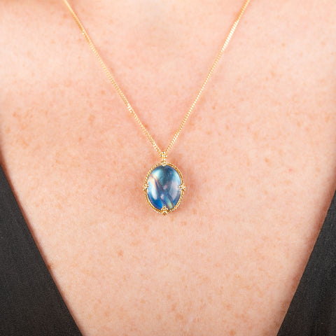Handmade gold necklace with a moonstone pendant in an 18k gold bezel on a person