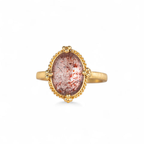 Handmade 18k gold ring featuring a Super 7 gemstone on a white background.