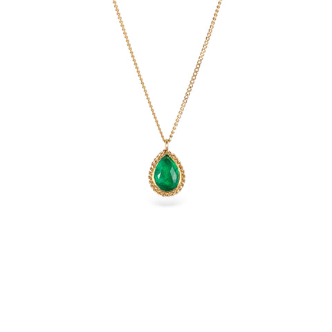 Gold necklace with a petite emerald gemstone set in a handmade gold bezel on a white background.