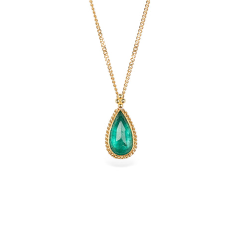Handcrafted gold necklace with a one-of-a-kind emerald teardrop pendant on a white background.