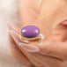 A gold and silver ring featuring a phosphosiderite stone, held in hand.
