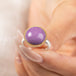 A gold and silver ring featuring a phosphosiderite stone, held in hand.