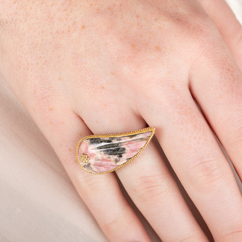 Carved rhodochrosite wing ring with a gold setting and silver band