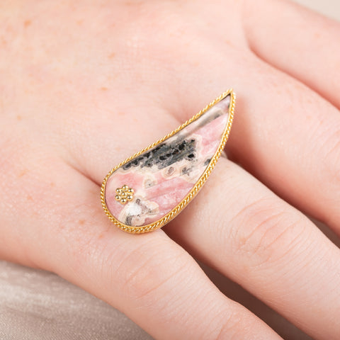 Carved rhodochrosite wing ring with a gold setting and silver band
