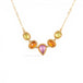 A gold necklace featuring a row of sapphire gemstones in different shapes and colors, shown against a white background.