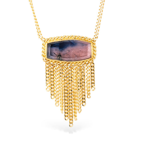 Gold necklace with a ruby sapphire gemstone pendant on a white background