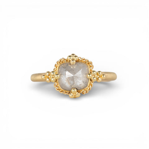 Gold ring with a silver diamond on a white background