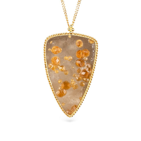 Gold necklace featuring spessartite garnet in quartz on a white background