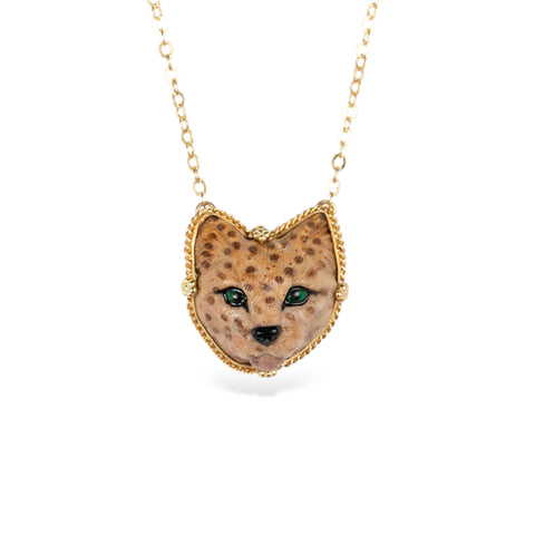 Handmade gold necklace featuring a carved spotted cat made of jasper on a white background.