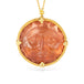 Gold necklace with a round sunstone pendant featuring a sun face design on a white background