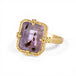 Gold ring with a purple Super 7 gemstone on a white background