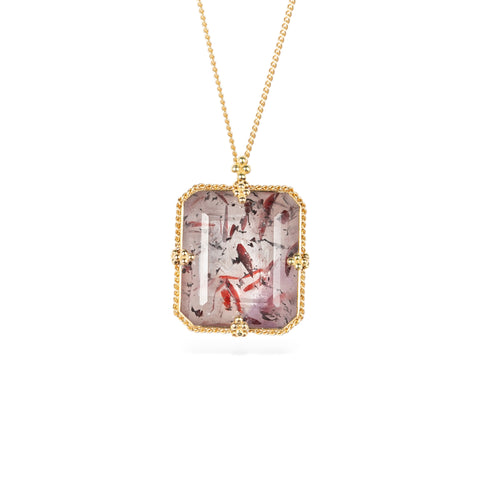 Handmade gold necklace with a Super 7 gemstone on a white background