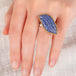 A hand carved tanzanite feather ring with a gold bezel and sterling silver band