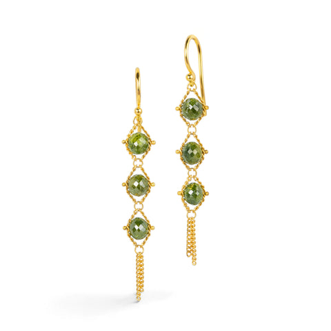 Gold earrings featuring trios of green diamonds, shown against a white background.