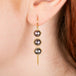 Gold trio earring featuring three grey akoya pearls, shown worn on a person's ear.