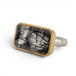 A rectangular ring featuring a tourmalated quartz crystal with visible needle-like inclusions, set in a gold bezel.
