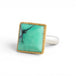 A gold and silver ring featuring a Variscite stone against a white backdrop.