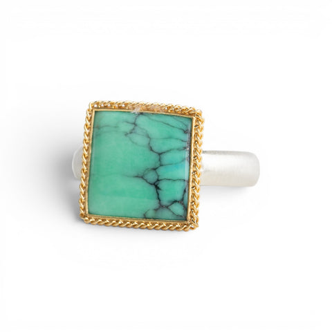 Gold and silver ring featuring a green Variscite stone against a white background