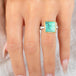 Gold and silver ring featuring a green Variscite stone worn on a finger