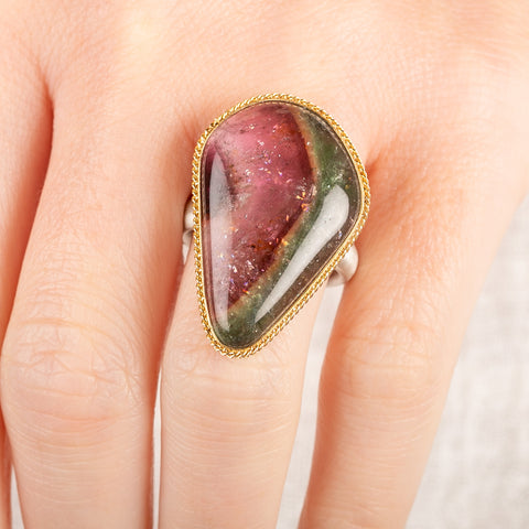 Ring with a teardrop-shaped watermelon tourmaline gemstone in a gold bezel with a sterling silver band