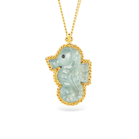 Seahorse-shaped aquamarine pendant with gold frame on a white background