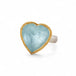 Heart-shaped ring with aquamarine stone, gold bezel and silver band on a white background