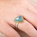 Aquamarine stone ring with gold setting and silver band on a person's finger