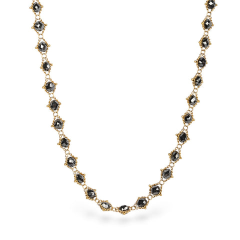 Gold necklace with black diamonds on a white background