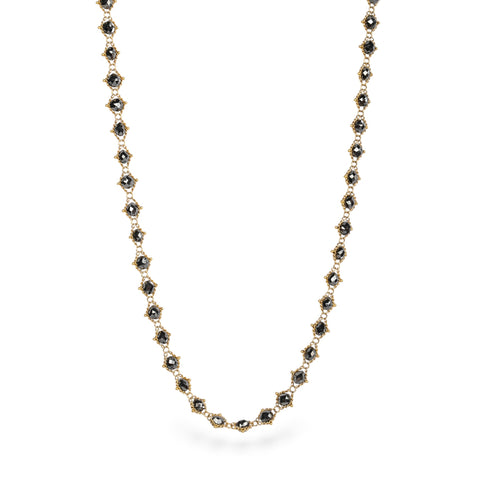 Gold necklace with black diamonds on a white background
