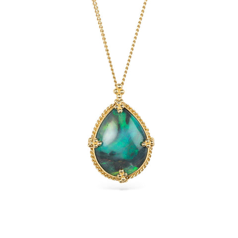 Gold necklace with a black opal teardrop pendant on a white background
