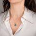 Gold necklace with a black opal teardrop pendant on a person's neck