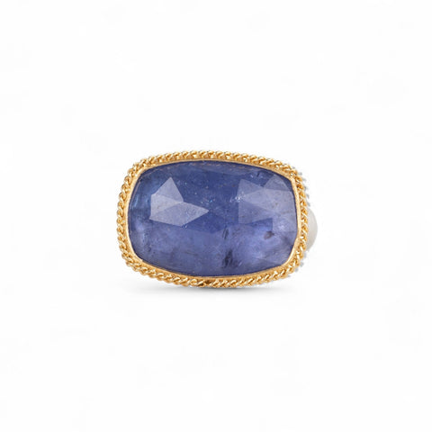 Tanzanite ring with gold bezel and sterling silver band on white background