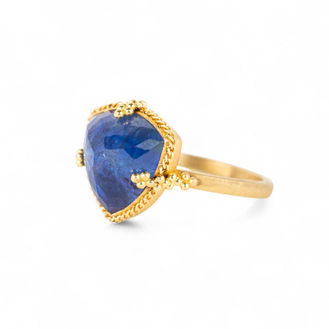 Gold ring with a tanzanite gemstone on a white background