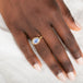 Gold ring with a blue dumortierite stone on a person's finger