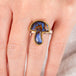 Hand wearing a boulder opal mushroom ring in gold and silver