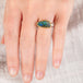 Hand wearing a boulder opal ring with gold bezel and sterling silver band