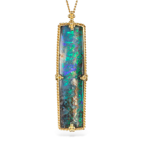 Boulder opal necklace with a handcrafted gold setting on a white background