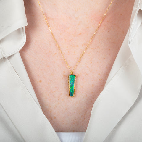 Australian Opal gemstone necklace with a gold setting on a person