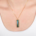 Boulder opal necklace with a handcrafted gold setting on a person