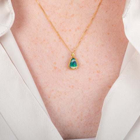 18k gold necklace featuring a boulder opal gemstone worn on a person
