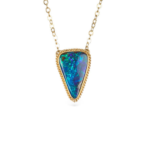 Gold necklace with a triangular boulder opal pendant on a white background