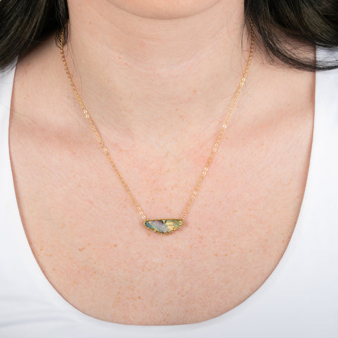 Boulder opal necklace with gold chain on a person
